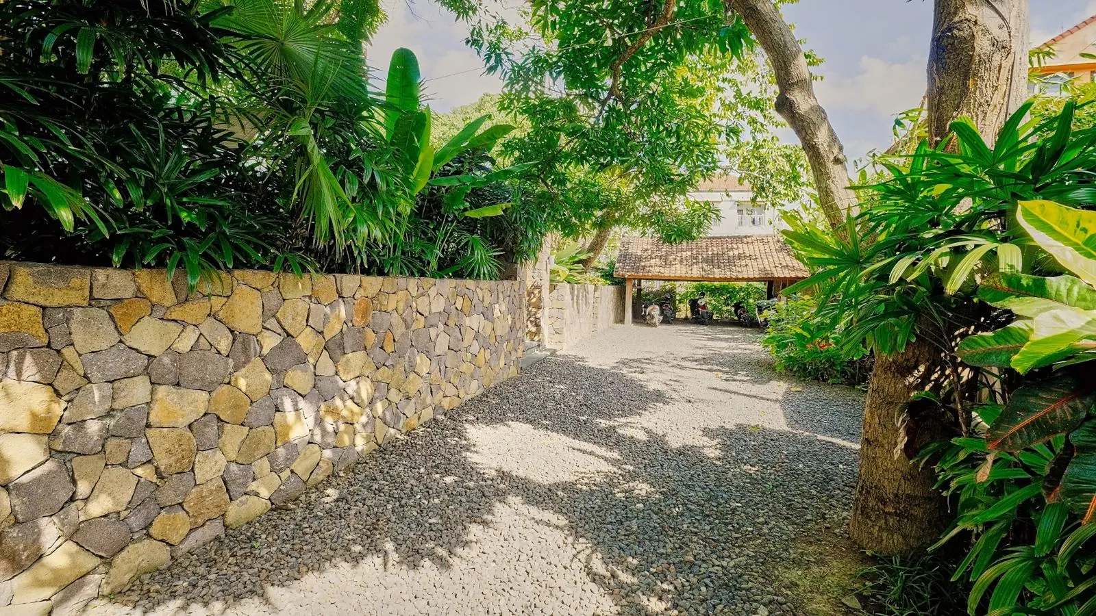 Allée d'entrée de la villa bordée de murs en pierre